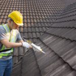 Worker man using silicone sealant adhesive to fix crack of the