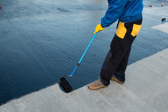 expert waterproofing the roof of a commercial building