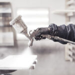 Staining wood with white spray gun, close-up shot.